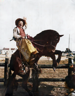 William J. Dumes, not really bronco busting, but at one of those things where you put your face into a painted foreground.